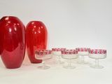 trois vases rouges posés les uns à côté des autres sur une table