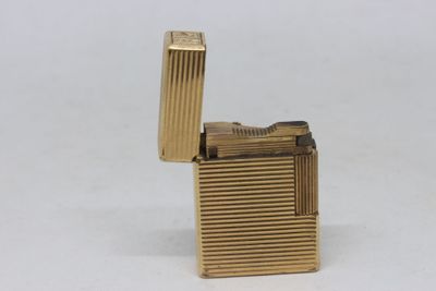 a gold lighter that is sitting on a white surface