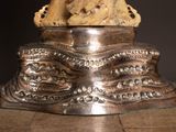 a statue of a dog sitting on top of a silver plate