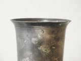 a metal vase that is sitting on a table