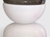 un vase noir et blanc posé sur une table blanche