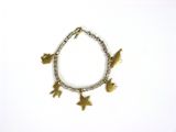 bracelet avec des breloques dorées et des oiseaux sur fond blanc