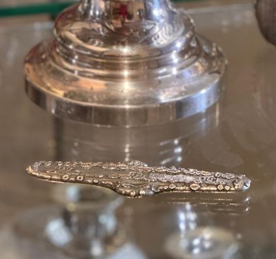 a silver spoon sitting on top of a glass table