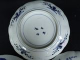 three plates with blue flowers on them on a black table