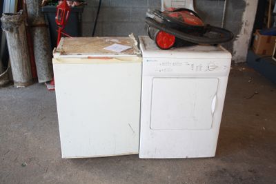 une machine à laver et un sèche-linge blancs dans un garage