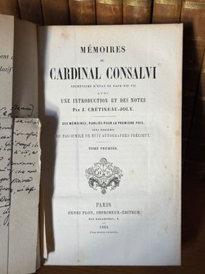 un livre posé sur une étagère parmi tout un tas de vieux livres