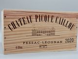 La caisse en bois contient une bouteille de vin.