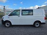 the white van is parked in the parking lot near a fence