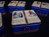 several tinned boxes with pictures of people on them sitting on a table