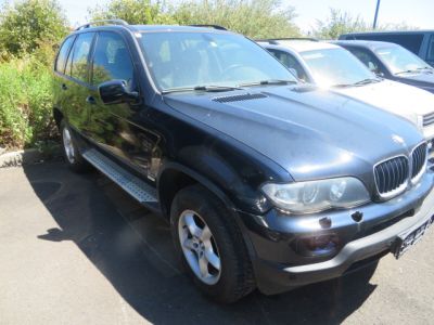 une photo d'un SUV BMW noir garé sur un parking