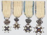 un ensemble composé de quatre médailles et d'une croix sur fond blanc
