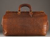 an old brown leather bag with a handle and handles