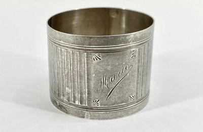 une tasse en argent posée sur une surface blanche