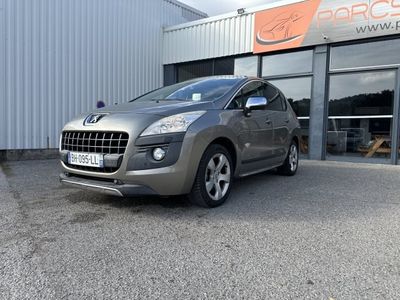 La voiture grise est garée à l'extérieur du bâtiment, devant celui-ci.