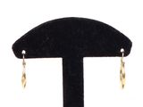 pair of yellow gold earrings on a black velvet stand