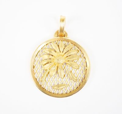 a gold plated pendant with a flower on it