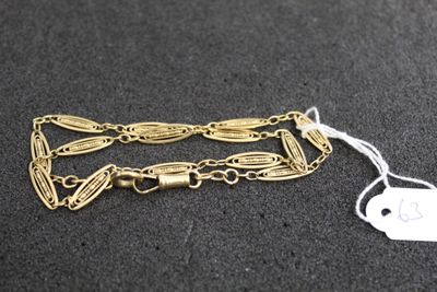 Gros plan sur un bracelet en chaîne en or portant une étiquette