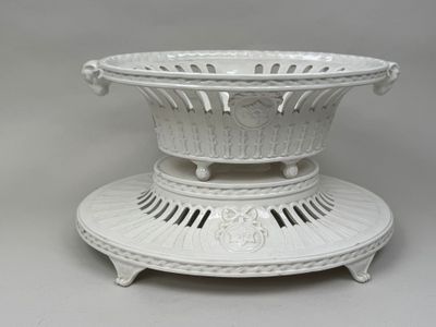 a large white bowl on a stand on a gray surface