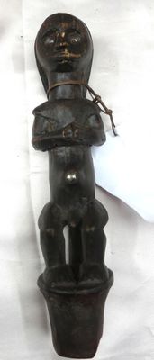 une vieille sculpture en bois représentant un homme tenant un bébé dans ses bras