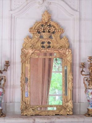 a mirror on a mantle with vases and a vase on it