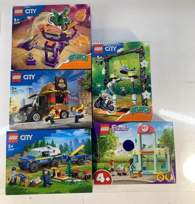 Quatre coffrets Lego City sont exposés sur une table