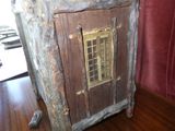 une petite armoire en bois avec une vitrine, posée sur une table
