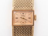a close up of a gold wrist watch on a white surface