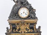a black and gold clock with a statue on it