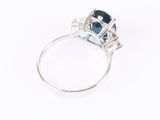 a close up of a ring with a blue sapphire and diamonds