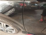 a man that is standing next to a car in a garage