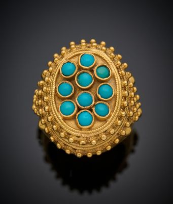 une bague en or sertie de turquoises sur un fond noir