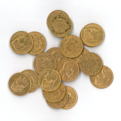 quelques pièces d'or posées sur une surface blanche, sur fond blanc