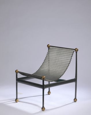 a black and gold lounge chair with a metal frame and metal legs