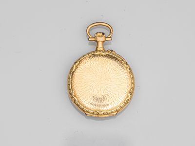 an antique gold pocket watch with a chain on a white surface