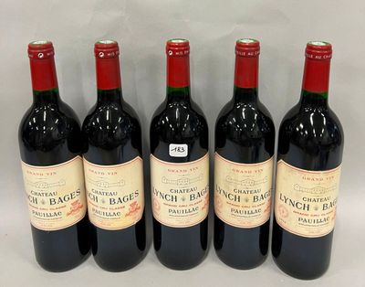 six bouteilles de vin rouge sont alignées sur une surface blanche