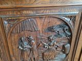 carvings on a wooden cabinet with a clock on top of it