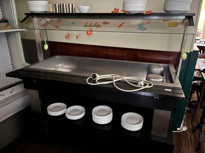 une photo d'une cuisine avec un évier et de la vaisselle posée sur le plan de travail