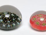 deux boules de verre posées l'une à côté de l'autre sur une surface blanche