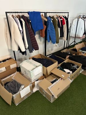 many boxes of clothes on a rack in a room