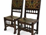 pair of carved wood chairs with floral designs on the backs