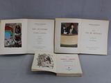 trois livres ouverts posés sur une table, sur lesquels figurent des photos de personnes