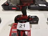 a red cordless drill on a table with other tools