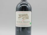 une bouteille de vin rouge posée sur une table blanche