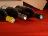 three bottles of wine sitting on a red cloth