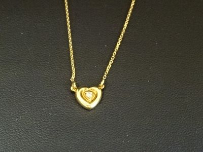un gros plan d'un collier en or orné d'un cœur