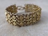 gros plan d'un bracelet en or sur une table
