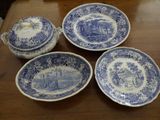four blue and white plates and a bowl sitting on a table