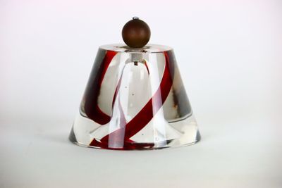 une cloche en verre surmontée d'une perle en bois