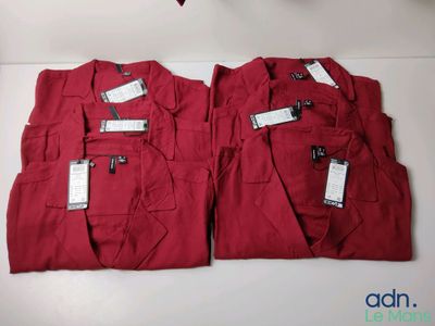 two pairs of red pants with tags on them sitting on a table