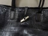 a black purse with a gold clasp on it